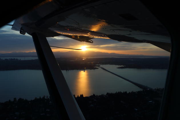 A great view from the Caravan cockpit of sunset reflecting from Lake Washington, with Seattle and the Olympic mountains in the distance.