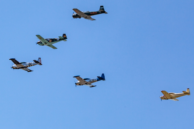Five of the six warbirds in the trailing Victory Bravo Flight crossing Boeing Field. Photo by Peter Reinold.