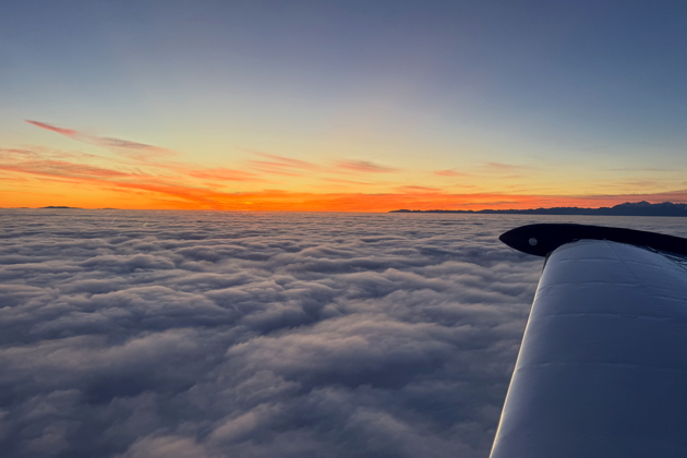 Sunset over a cloud-blanketed Puget Sound as we prepare for our night RNAV 17 approach into Tacoma in the Comanche. My photo.