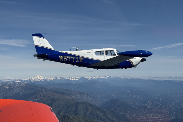 Joining with Kevin Franklin in his Comanche over Cle Elum Lake, with Glacier Peak and Mt. Baker in the distance. Photo by Rob Smith.